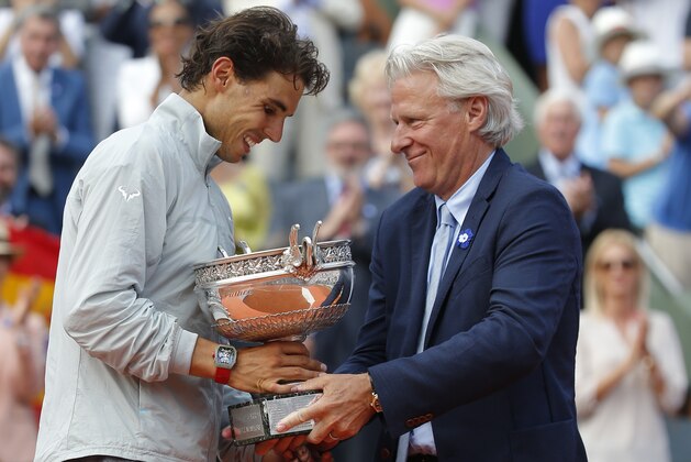 Spain's Rafael Nadal, left, gets the cup from Swedish tennis legend Bjorn Borg after defeating Serbia's Novak Djokovic in their final match of  the French Open tennis tournament at the Roland Garros stadium, in Paris, France, Sunday, June 8, 2014. Nadal won 3-6, 7-5, 6-2, 6-4. (AP Photo/Michel Euler)