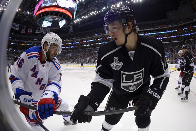 New York Rangers center Derick Brassard, left, and Los Angeles Kings center Tyler Toffoli battle for the puck during the second overtime period in Game 2 of the NHL hockey Stanley Cup Finals, Saturday, June 7, 2014, in Los Angeles. The Kings won 5-4.  (AP Photo/Mark J. Terrill)