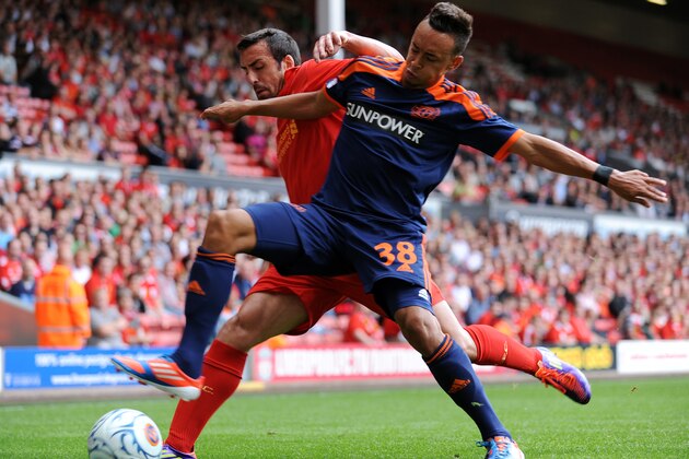 LIVERPOOL, ENGLAND - AUGUST 12:  Jose Enrique (L) of Liverpool and Karim Bellarabi (R) of Bayer Leverkusen battle for the ball during the pre season friendly match between Liverpool and Bayer Leverkusen at Anfield on August 12, 2012 in Liverpool, England. (Photo by Clint Hughes/Getty Images)