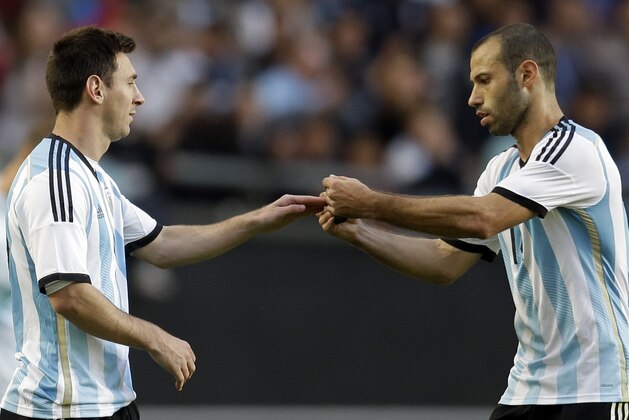 Argentina's Javier Mascherano, right, gives the captain arm band to Argentina's Lionel Messi during their international friendly soccer match in La Plata, Argentina, Saturday, June 7, 2014. Argentina's team is leaving June 9 for Brazil to compete in the World Cup. (AP Photo/Natacha Pisarenko)