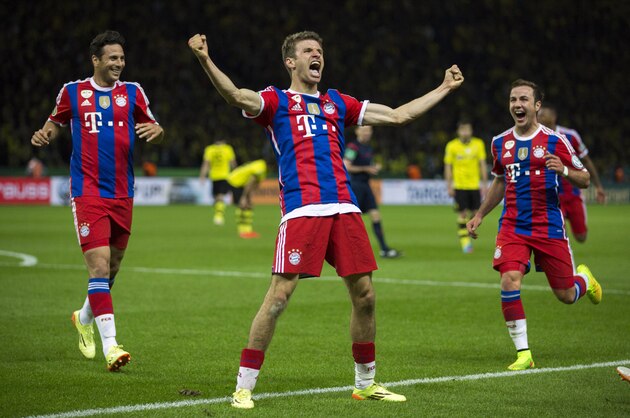 Bayern's Thomas Mueller, center, celebrates scoring his side's second goal during the German Soccer Cup Final between FC Bayern Munich and Borussia Dortmund at the Olympic Stadium in Berlin, Germany, Saturday, May 17, 2014. (AP Photo/Gero Breloer)