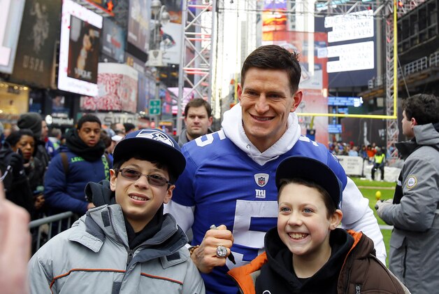 Jan 31, 2014; New York, NY, USA; New York Giants player Steve Weatherford poses for a photo with Seattle Seahawks fans on Super Bowl Boulevard in Time Square on Broadway in advance of Super Bowl XLVIII. Mandatory Credit: Adam Hunger-USA TODAY Sports