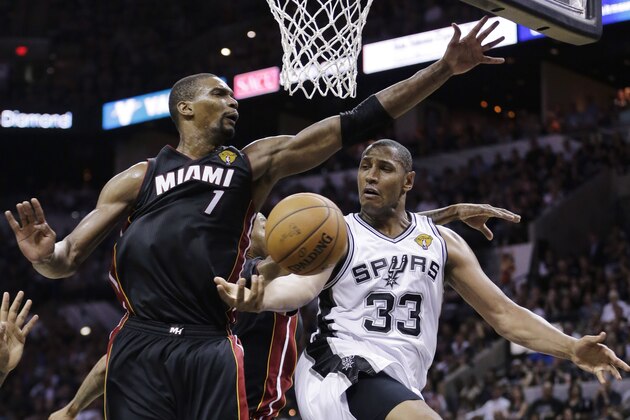 San Antonio Spurs forward Boris Diaw (33) passes around Miami Heat center Chris Bosh (1) during the second half in Game 2 of the NBA basketball finals on Sunday, June 8, 2014, in San Antonio. (AP Photo/Eric Gay)