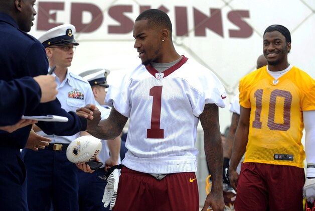 Washington Redskins wide receiver DeSean Jackson shakes hands with military personnel as quarterback Robert Griffin III (10)  looks on after their NFL organized team activity at Redskins training facility Thursday, May 29, 2014, in Ashburn, Va. Members of the military were guest visitors to the Redskins practice. (AP Photo/Richard Lipski)