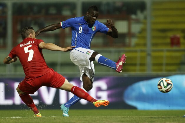Italy forward Mario Balotelli, right, makes an attempt to score as Luxembourg defender Tom Schnell tackles him during a friendly World Cup preparation soccer match between Italy and Luxembourg in Perugia, Italy, Wednesday, June 4, 2014. Italy opens its Brazilian World Cup campaign against England in Group D on June 14 then faces Costa Rica on June 20 and Uruguay on June 24. (AP Photo/Luca Bruno)