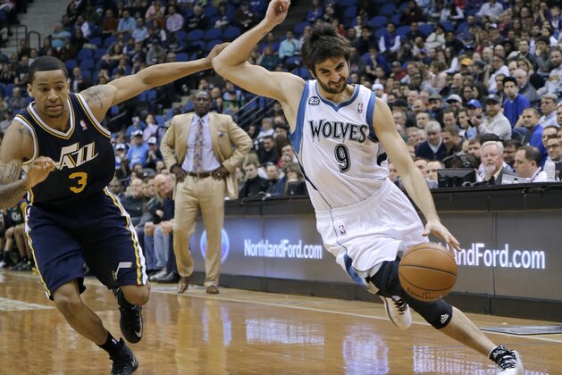 Minnesota Timberwolves guard Ricky Rubio (9), of Spain, tries to shake off Utah Jazz guard Trey Burke (3) on a drive during the fourth quarter of an NBA basketball game in Minneapolis, Wednesday, April 16, 2014. The Jazz won 136-130 in double overtime. (AP Photo/Ann Heisenfelt)