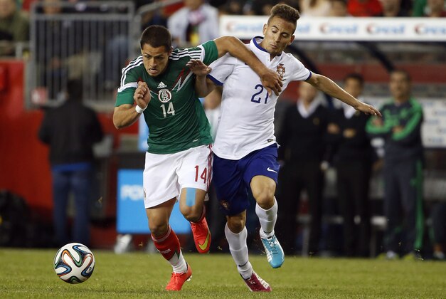 Jun 6, 2014; Foxborough, MA, USA; Portugal defender Jo  o Pereira (21) battles  Mexico forward Javier Hern  ndez (14) for the ball during the second half of Portugal's 1-0 win in an international friendly at Gillette Stadium. Mandatory Credit: Winslow Townson-USA TODAY Sports