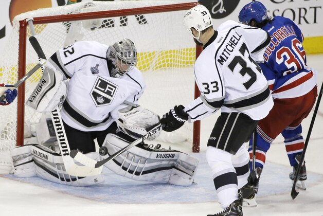 Los Angeles Kings goalie Jonathan Quick (32) blocks a shot by New York Rangers right wing Mats Zuccarello (36) as Kings defenseman Willie Mitchell (33) helps defend in the second period during Game 3 of the NHL hockey Stanley Cup Final, Monday, June 9, 2014, in New York. (AP Photo/Frank Franklin II)