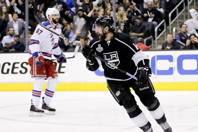 Los Angeles Kings right wing Justin Williams, right, celebrates his game winning goal as New York Rangers left wing Benoit Pouliot looks on in overtime of Game 1 in the NHL Stanley Cup Final hockey series on Wednesday, June 4, 2014, in Los Angeles.(AP Photo/Jae C. Hong)
