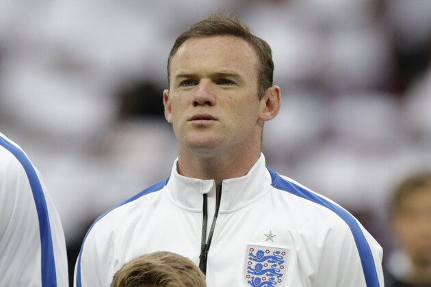 England's Wayne Rooney stands in a team line up during the playing of the national anthems before the international friendly soccer match between England and Peru at Wembley Stadium in London, Friday, May 30, 2014.  (AP Photo/Matt Dunham)