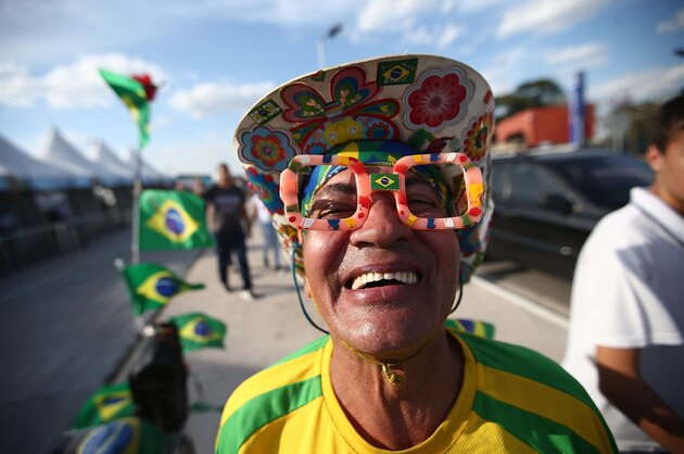 SAO PAULO, BRAZIL - JUNE 08:  A Brazil fans poses outside of opening ceremony rehearsals around Itaquerao stadium, also known as Arena de Sao Paulo and Arena Corinthians, on June 8, 2014 in Sao Paulo, Brazil. Hundreds of fans turned up at the stadium to take a peek on the final Sunday before the opening of the 2014 FIFA World Cup match on June 12 between Brazil and Croatia. Brazil has won five World Cups, more than any other nation. (Photo by Mario Tama/Getty Images)