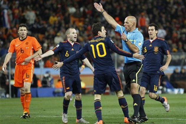 Spain's Cesc Fabregas, center with back to camera, and Spain's Andres Iniesta, second from left, contest a decision by referee Howard Webb, of England, second from right, during the World Cup final soccer match between the Netherlands and Spain at Soccer City in Johannesburg, South Africa, Sunday, July 11, 2010.  (AP Photo/Bernat Armangue)