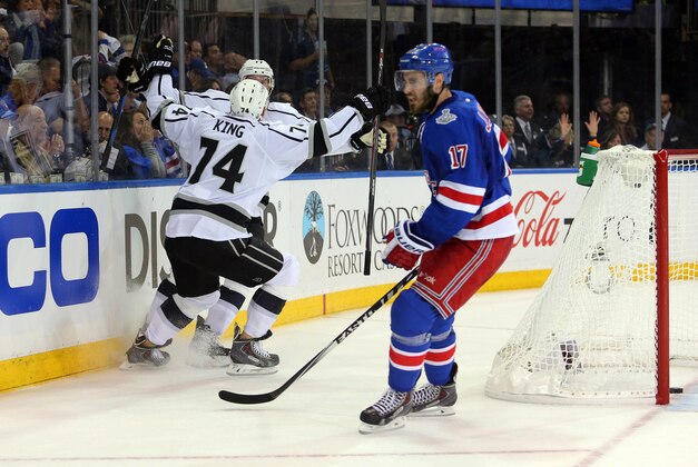 Jun 9, 2014; New York, NY, USA; Los Angeles Kings center Jeff Carter (rear) celebrates with left wing Dwight King (74) after scoring a goal as New York Rangers defenseman John Moore (17) skates away during the first period in game three of the 2014 Stanley Cup Final at Madison Square Garden. Mandatory Credit: Brad Penner-USA TODAY Sports