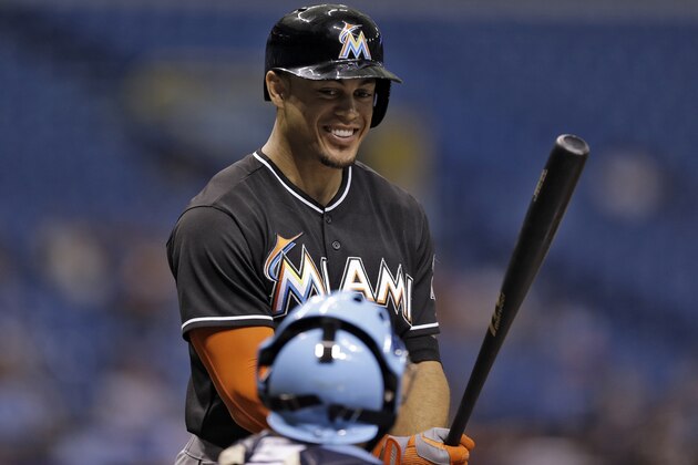 Miami Marlins' Giancarlo Stanton smiles as he talk to Tampa Bay Rays catcher Jose Molina prior to batting during the first inning of an interleague baseball game Wednesday, June 4, 2014, in St. Petersburg, Fla. (AP Photo/Chris O'Meara)