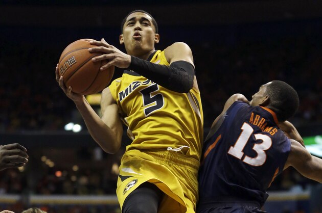 Missouri's Jordan Clarkson, center, heads to the basket as Illinois' Jon Ekey, left, and Tracy Abrams defend during the second half of an NCAA college basketball game on Saturday, Dec. 21, 2013, in St. Louis. Illinois won 65-64. (AP Photo/Jeff Roberson)