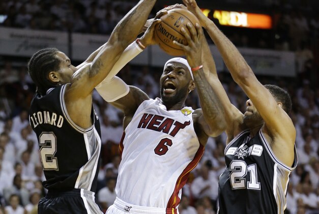 San Antonio Spurs forward Tim Duncan (21) and forward Kawhi Leonard (2) defend Miami Heat forward LeBron James (6), during the first half in Game 3 of the NBA basketball finals, Tuesday, June 10, 2014, in Miami. (AP Photo/Wilfredo Lee)