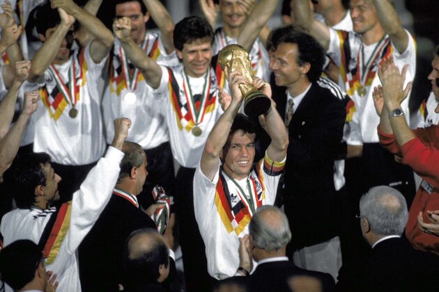 Germany soccer team players celebrate after winning the Soccer World Cup final in the Olympic Stadium, in Rome, Italy, on July 8, 1990. Germany defeated Argentina 1-0 to win the cup. Player lifting the cup is German captain Lothar Matthaus. German soccer coach Franz Beckenbauer, in dark jacket, is seen behind Matthaus. (AP Photo/Carlo Fumagalli)
