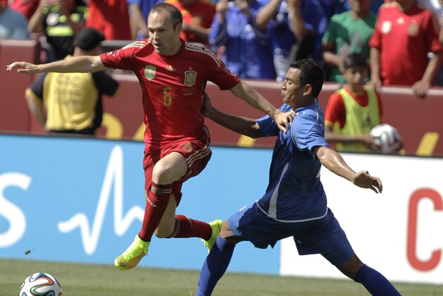 Spain’s Andres Iniesta (6) moves the ball as El Salvador’s Xavier Garcia, right, defends during the first half of an exhibition soccer game, Saturday, June 7, 2014, in Landover, Md. Spain won 2-0. (AP Photo/Luis M. Alvarez)