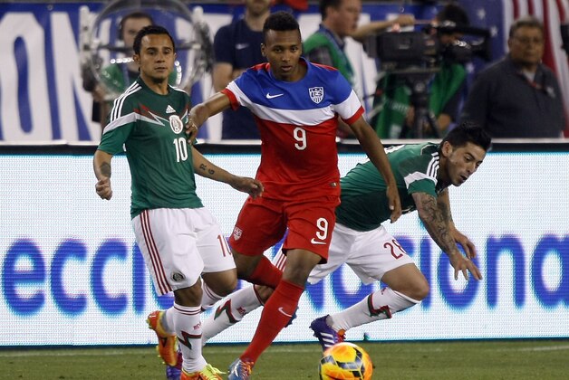 U.S. Julian Green (9) battles for the ball with Mexico defenders during the second half of an international friendly soccer match Wednesday, April 2, 2014, in Glendale, Ariz. The game ended in a 2-2 draw. (AP Photo/Rock Scuteri)