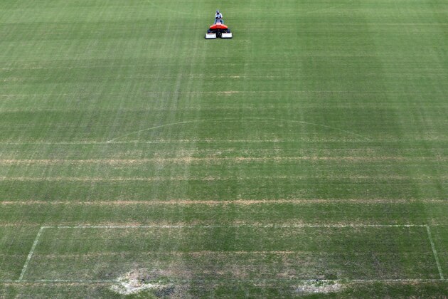 A groundsman cuts the grass at the 2014 soccer World Cup venue at the Arena da Amazonia in Manaus, Brazil, Wednesday June 11, 2014. (AP Photo/Themba Hadebe)