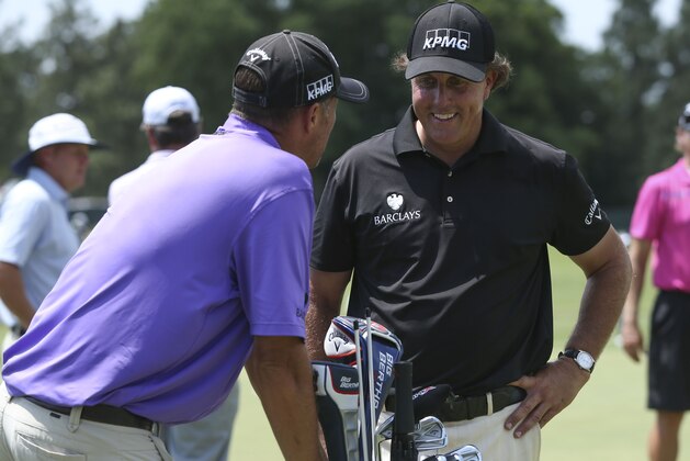 Jun 11, 2014; Pinehurst, NC, USA; Phil Mickelson (right) and caddie Jim Mackay (left) talk on the practice green during a practice round for the U.S. Open golf tournament at Pinehurst No. 2 at Pinehurst Resort & Country Club. Mandatory Credit: Jason Getz-USA TODAY Sports