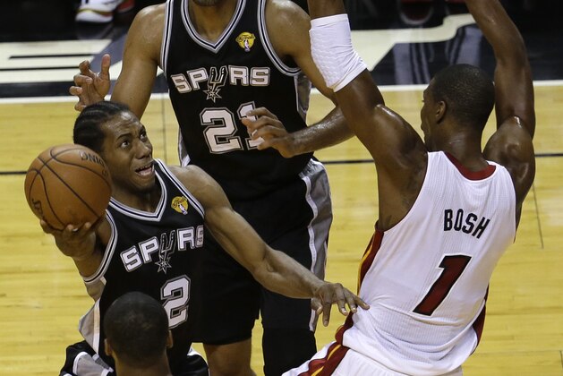 San Antonio Spurs forward Kawhi Leonard (2) goes to the basket against Miami Heat center Chris Bosh (1) in the first half in Game 3 of the NBA basketball finals, Tuesday, June 10, 2014, in Miami.  (AP Photo/Lynne Sladky)
