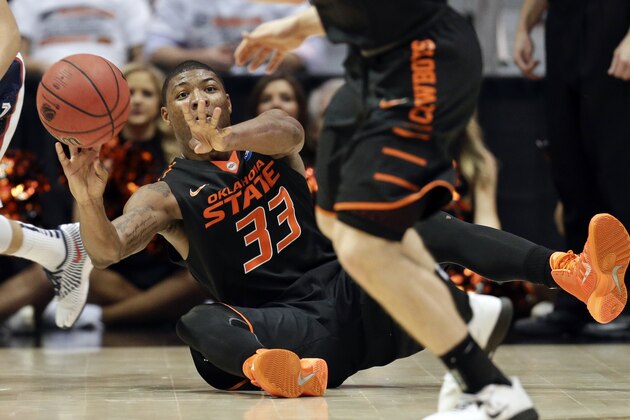 Oklahoma State's Marcus Smart passes to a teammate after diving for a loose ball against Gonzaga during the second half in a second-round game in the NCAA college basketball tournament Friday, March 21, 2014, in San Diego. (AP Photo/Gregory Bull)