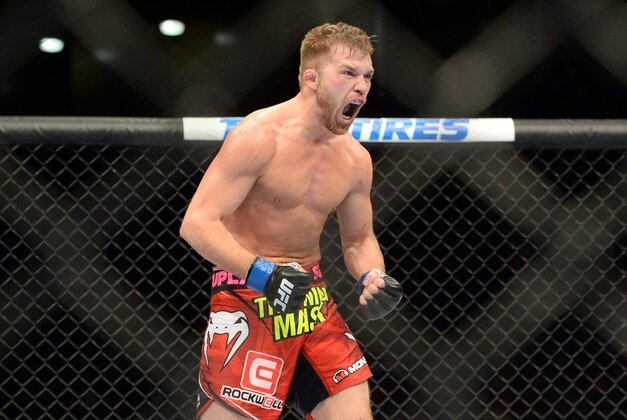Jun 7, 2014; Albuquerque, NM, USA; Bryan Caraway (blue) celebrates his victory over Erik Perez their bantamweight bout during UFC Fight Night 42 at Tingley Coliseum. Caraway won via second round submission. Mandatory Credit: Joe Camporeale-USA TODAY Sports