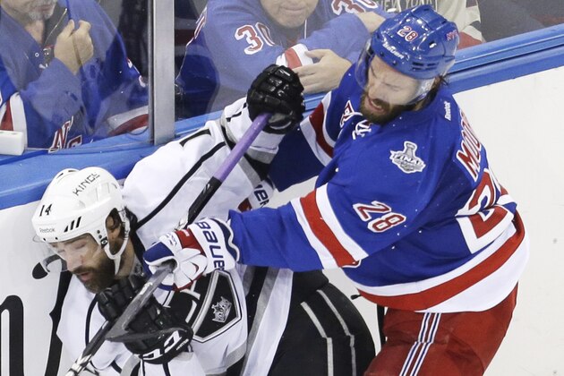 New York Rangers center Dominic Moore (28) crashes the boards against Los Angeles Kings right wing Justin Williams (14) in the third period during Game 4 of the NHL hockey Stanley Cup Final, Wednesday, June 11, 2014, in New York. The Rangers won the game 2-1. (AP Photo/Seth Wenig)