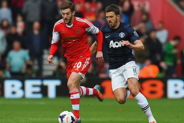 SOUTHAMPTON, ENGLAND - MAY 11:  (L-R) Adam Lallana of Southampton holds off Michael Carrick of Manchester United during the Barclays Premier League match between Southampton and Manchester United at St Mary's Stadium on May 11, 2014 in Southampton, England.  (Photo by Mike Hewitt/Getty Images)