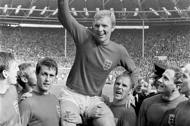 England's captain Bobby Moore chaired by hat-trick hero Geoff Hurst (left) and Ray Wilson as he salutes the crowd with the Jules Rimet Trophy after their 4-2 victory against West Germany at Wembley, on July 30, 1966. England beat West Germany 4-2 after extra-time at Wembley. (AP Photo/Bippa)