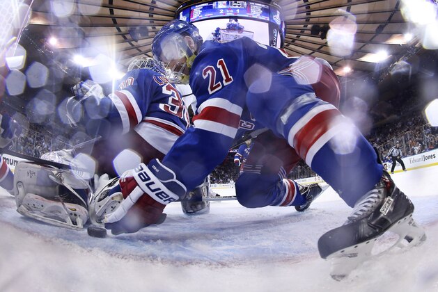 New York Rangers center Derek Stepan (21) reaches to move the puck away from the goal behind goalie Henrik Lundqvist (30) in the third period during Game 4 of the NHL hockey Stanley Cup Final, Wednesday, June 11, 2014, in New York. The Rangers won the game 2-1. (AP Photo/Bruce Bennett, Pool)