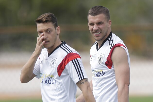 German's national soccer player Mesut Ozil, left, and Lukas Podolski watch their team mates during a training session near Porto Seguro, Brazil, Monday, June 9, 2014. Germany will play in group G of Brazil's 2014 soccer World Cup. (AP Photo/Matthias Schrader)