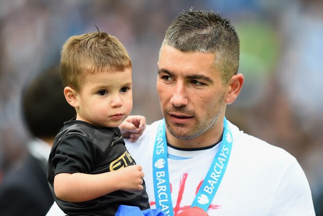 MANCHESTER, ENGLAND - MAY 11:  Aleksandar Kolarov of Manchester City looks on with his son at the end of the Barclays Premier League match between Manchester City and West Ham United at the Etihad Stadium on May 11, 2014 in Manchester, England.  (Photo by Shaun Botterill/Getty Images)