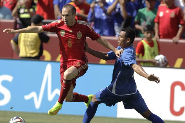 Spain’s Andres Iniesta (6) moves the ball as El Salvador’s Xavier Garcia, right, defends during the first half of an exhibition soccer game, Saturday, June 7, 2014, in Landover, Md. Spain won 2-0. (AP Photo/Luis M. Alvarez)