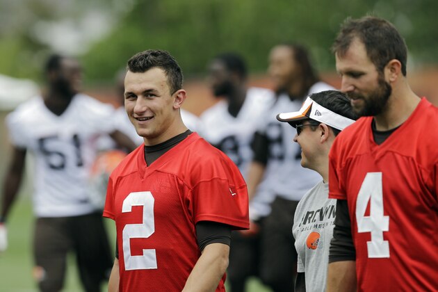 Cleveland Browns quarterback Johnny Manziel (2) walks off the field with Tyler Thigpen (4) and quarterbacks coach Dowell Loggains after a mandatory minicamp practice at the NFL football team's facility in Berea, Ohio Thursday, June 12, 2014.  (AP Photo/Mark Duncan)