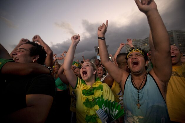 Brazil soccer fans celebrate their team's goal against Croatia as they watch the game inside the FIFA Fan Fest area on Copacabana beach in Rio de Janeiro, Brazil, Thursday, June 12, 2014. (AP Photo/Silvia Izquierdo)