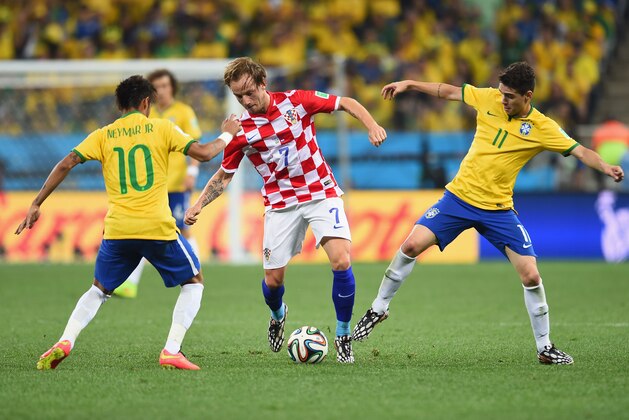 SAO PAULO, BRAZIL - JUNE 12:  Ivan Rakitic of Croatia controls the ball against Neymar (L) and Oscar of Brazil (R) during the 2014 FIFA World Cup Brazil Group A match between Brazil and Croatia at Arena de Sao Paulo on June 12, 2014 in Sao Paulo, Brazil.  (Photo by Buda Mendes/Getty Images)