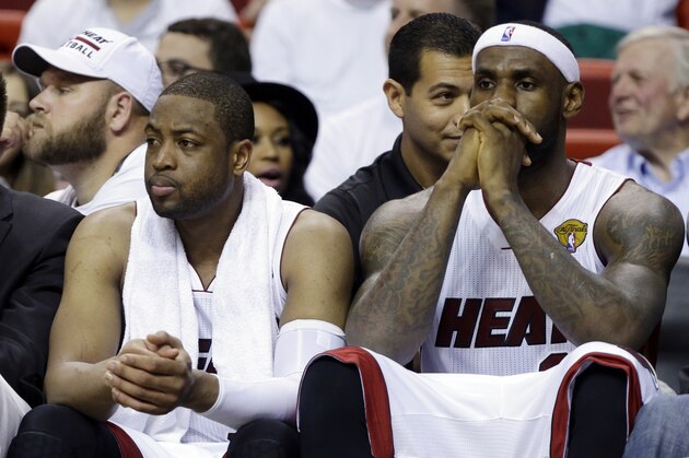 Miami Heat forward LeBron James, right and guard Dwyane Wade sit on the bench during the last minutes in the second half in Game 4 of the NBA basketball finals against the San Antonio Spurs, Thursday, June 12, 2014, in Miami.  The Spurs defeated the Heat 107-86. (AP Photo/Lynne Sladky)