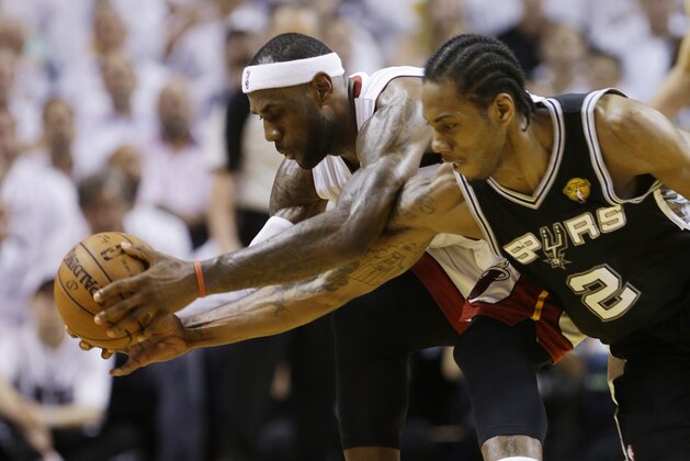 Miami Heat forward LeBron James (6) and San Antonio Spurs forward Kawhi Leonard (2) go after a loose ball during the first half in Game 4 of the NBA basketball finals, Thursday, June 12, 2014, in Miami.  (AP Photo/Lynne Sladky)