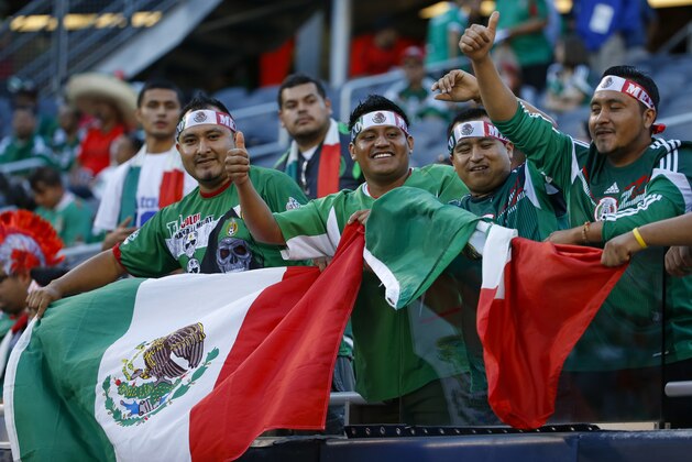 Mexico fans wave their national flag before Mexico's international friendly soccer match against Bosnia-Herzegovina at Soldier Field in Chicago, Tuesday, June 3, 2014. (AP Photo/Kamil Krzaczynski)