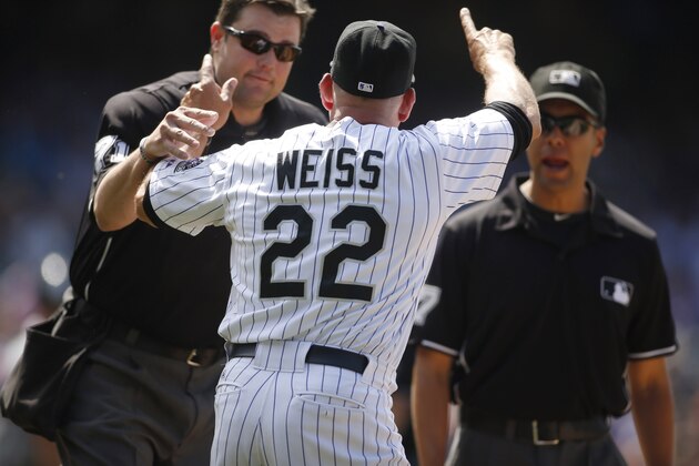 Jun 12, 2014; Denver, CO, USA; Colorado Rockies manager Walt Weiss (22) is restrained by home plate umpire Jordan Baker (left) after being ejected during the eighth inning against the Atlanta Braves at Coors Field. The Rockies won 10-3.  Mandatory Credit: Chris Humphreys-USA TODAY Sports