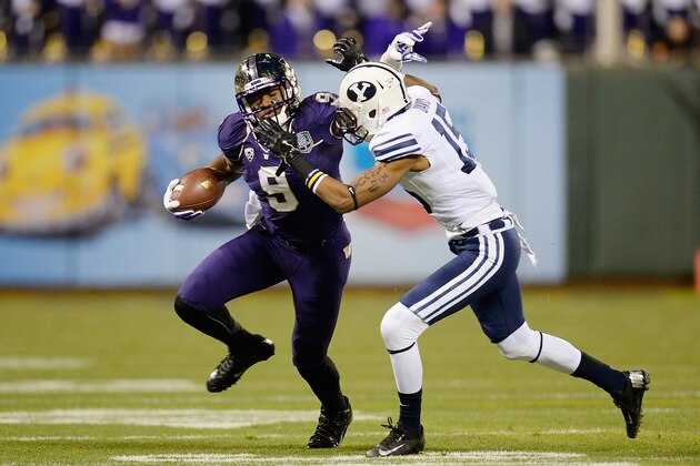 SAN FRANCISCO, CA - DECEMBER 27:  Damore'ea Stringfellow #9 of the Washington Huskies stiff arms would be tackler Michael Davis #15 of the BYU Cougars during the first quarter in the Fight Hunger Bowl at AT&T Park on December 27, 2013 in San Francisco, California.  (Photo by Thearon W. Henderson/Getty Images)