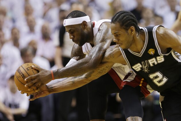 Miami Heat forward LeBron James (6) and San Antonio Spurs forward Kawhi Leonard (2) go after a loose ball during the first half in Game 4 of the NBA basketball finals, Thursday, June 12, 2014, in Miami.  (AP Photo/Lynne Sladky)