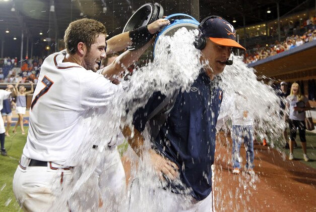 Virginia head coach Brian O'Connor gets doused with water by Virginia's Branden Cogswell (7) after Virginia defeated Maryland 11-2 to win the NCAA Super Regional baseball game in Charlottesville, Va., Monday, June 9, 2014. (AP Photo/Steve Helber)