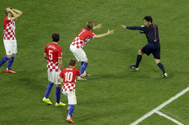 Referee Yuichi Nishimura from Japan, right, decides on penalty during the group A World Cup soccer match between Brazil and Croatia, the opening game of the tournament, in the Itaquerao Stadium in Sao Paulo, Brazil, Thursday, June 12, 2014. (AP Photo/Thanassis Stavrakis)