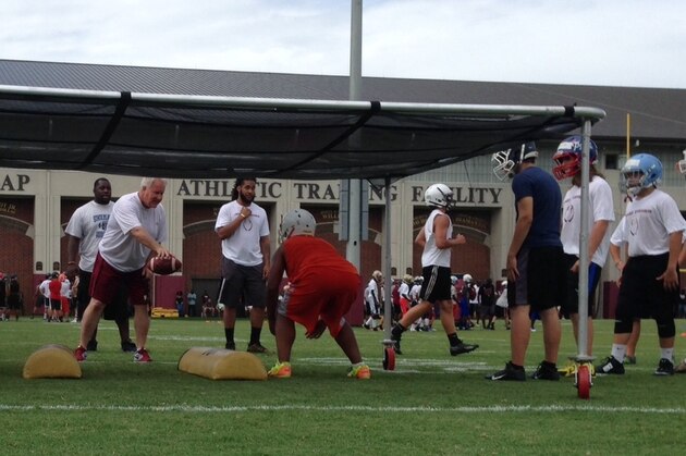 New linebackers coach Bill Miller (holding football) works out recruits during Jimbo Fisher's football camp this week.
