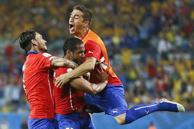 Chile's Jean Beausejour, center, celebrates with teammates after scoring his side's third goal during the group B World Cup soccer match between Chile and Australia in the Arena Pantanal in Cuiaba, Brazil, Friday, June 13, 2014.   (AP Photo/Frank Augstein)