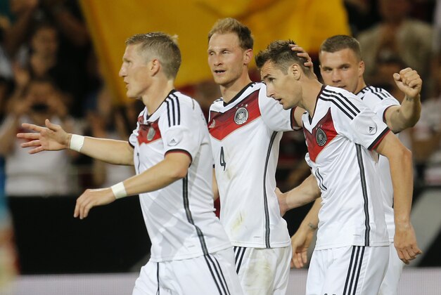 Germany's Miroslav Klose, second right, celebrates his side's fourth goal with team mates Lukas Podolski, right, Benedikt Hoewedes and Bastian Schweinsteiger, left, during a soccer friendly match between Germany and Armenia in the Coface Arena in Mainz, Germany, Friday, June 6, 2014. (AP Photo/Michael Probst)