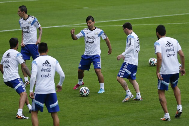 Argentina's Sergio Aguero, center, kicks the ball next to teammate  Lionel Messi, second right, during a training session in Vespasiano, near Belo Horizonte, Brazil, Thursday, June 12, 2014. Argentina will play in group F of the Brazil 2014 soccer World Cup. (AP Photo/Victor R. Caivano)